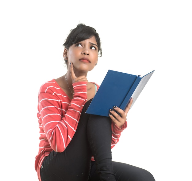 Pretty young girl holding book and posing on white background