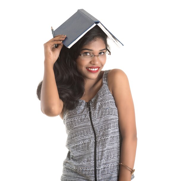 Pretty young girl holding book and posing on white background