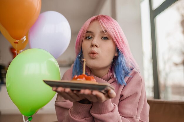 Photo a pretty young girl holding a saucer with a cake