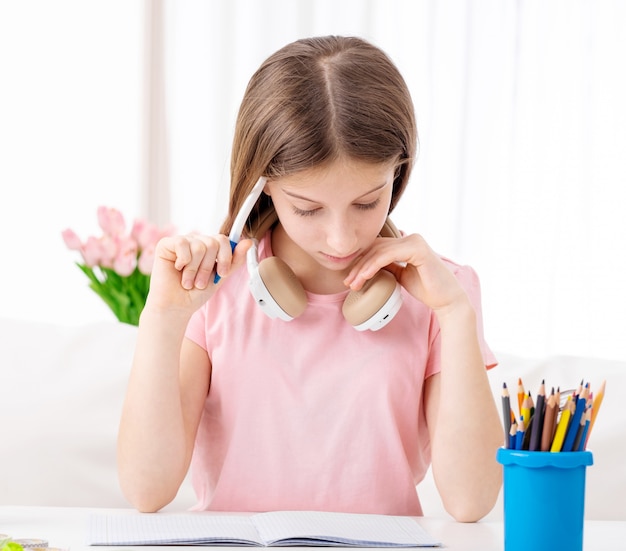 Pretty young girl learning with headphones