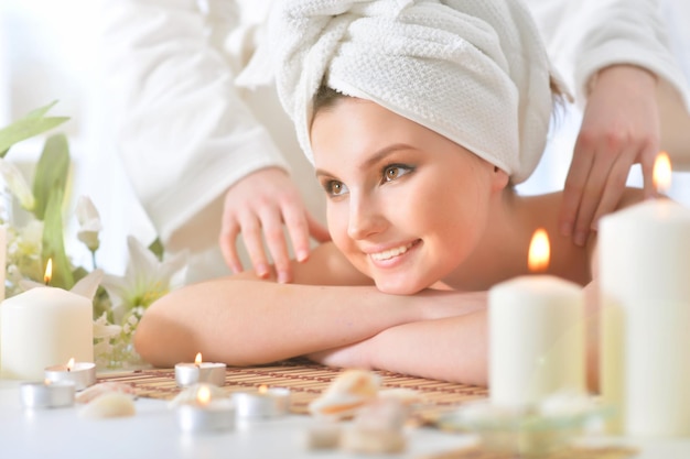 Pretty young girl lying down on a massage bed at a spa