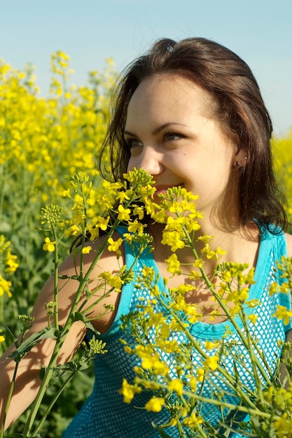 Pretty young girl in the middle of a field of yellow flowers
