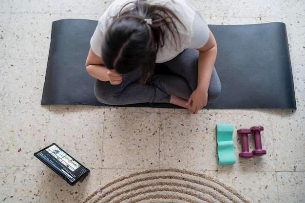 pretty young girl practicing exercise and yoga in her living room with a black cat