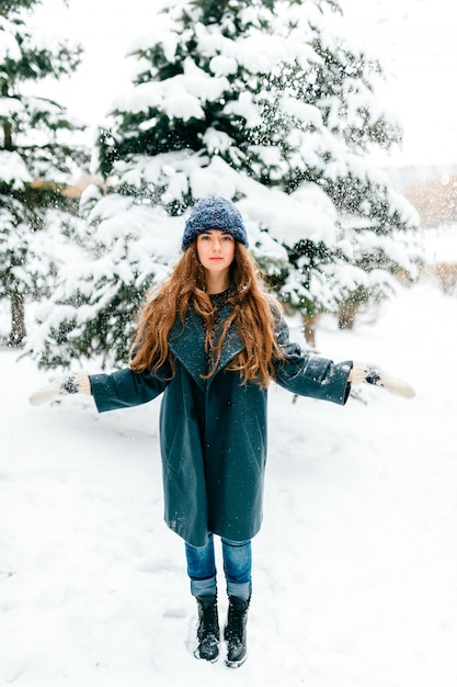 Pretty young long haired brunette posing in snowy winter park