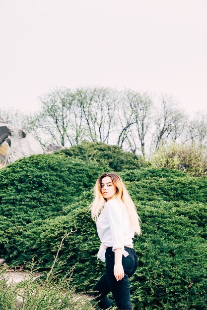 A pretty young long haired girl walking in a park