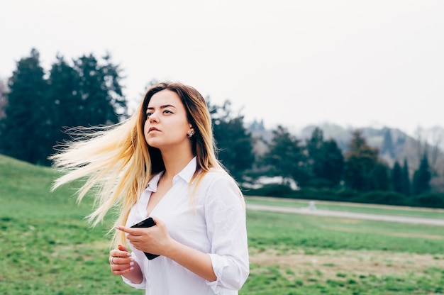 Pretty young long haired woman in the windy park