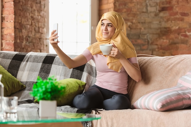 A pretty young muslim woman at home during quarantine and self-insulation