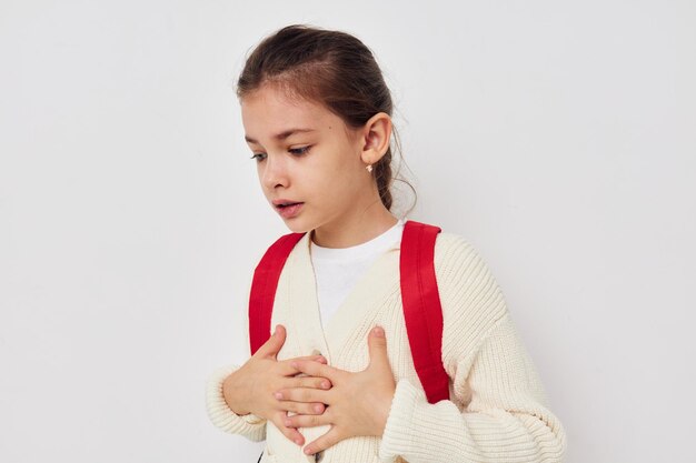 Pretty young schoolgirl with red backpack posing Lifestyle unaltered