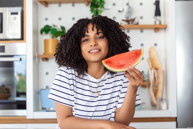 Pretty young smiling woman eating watermelon woman holding watermelon slice