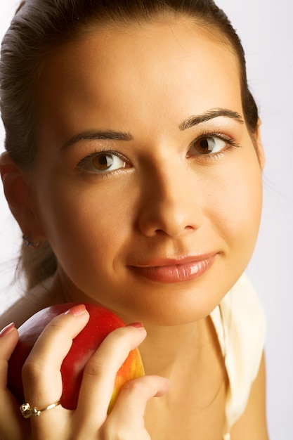 Pretty young smiling woman with red apple.