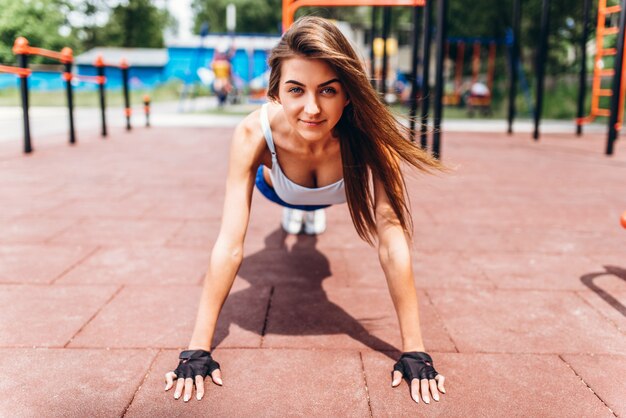 Pretty young sporty girl workout outdoor on the street.