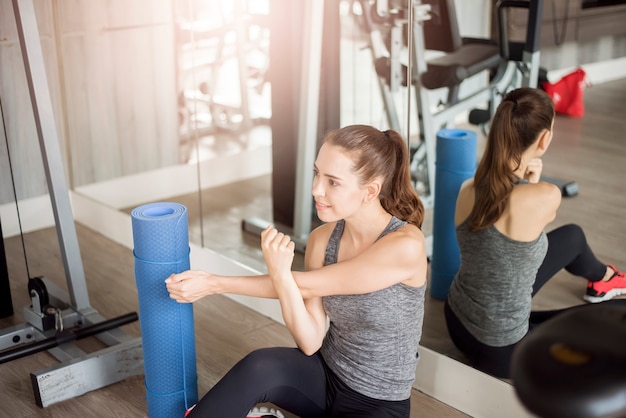 Pretty young sporty woman is warm up in gym