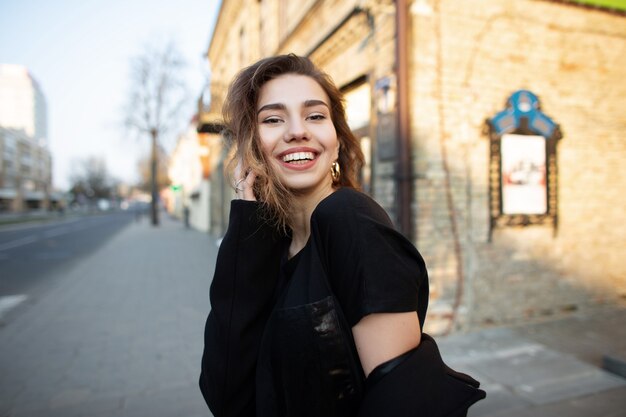 Pretty young woman in black stylish clothes