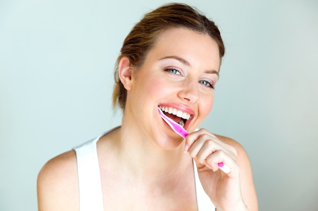 Photo pretty young woman brushing her teeth in the bathroom at home.