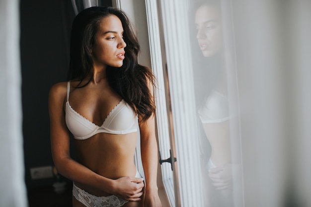 Photo pretty young woman by the window