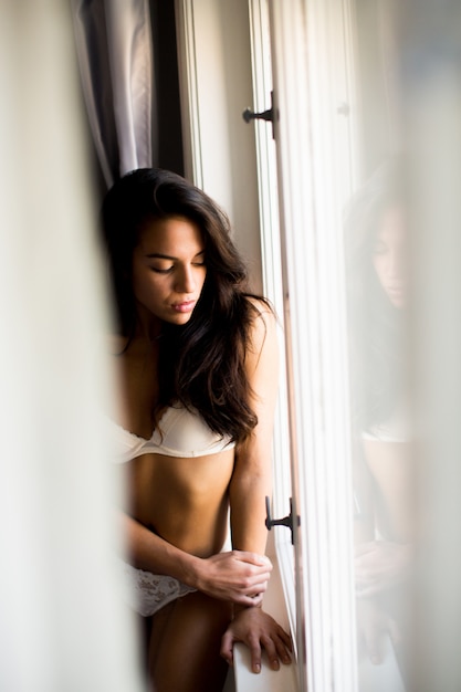 Photo pretty young woman by the window