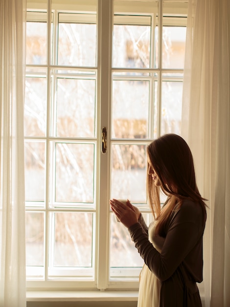 Pretty young woman by the window