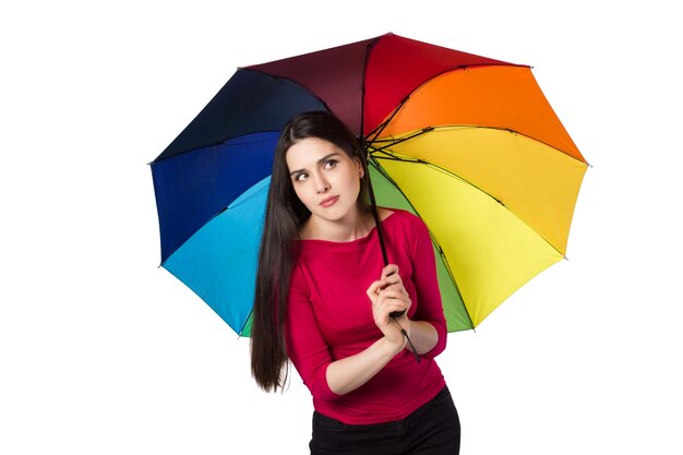 Pretty young woman under colorful umbrella, isolated on white background