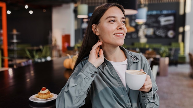 Foto donna abbastanza giovane che gode di una pausa caffè