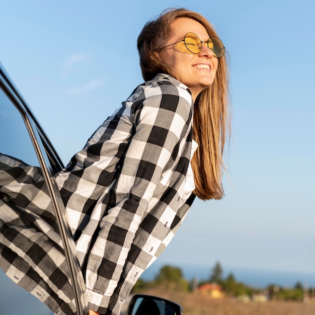 Foto donna abbastanza giovane che gode del viaggio su strada