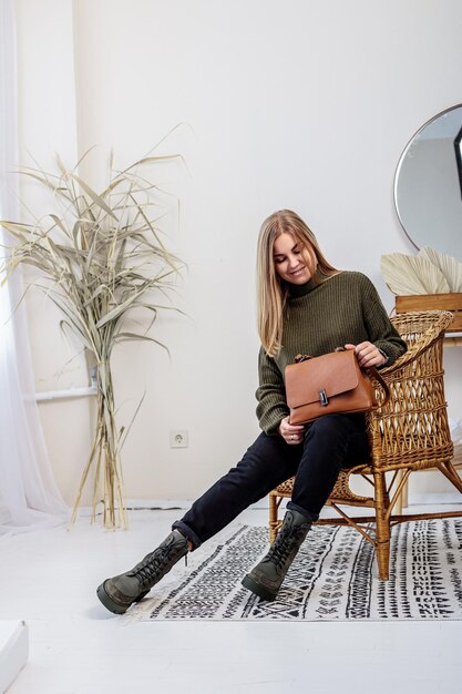 Foto piuttosto giovane donna in abiti alla moda con jeans neri e scarpe alla moda. belle gambe femminili in stivali di pelle