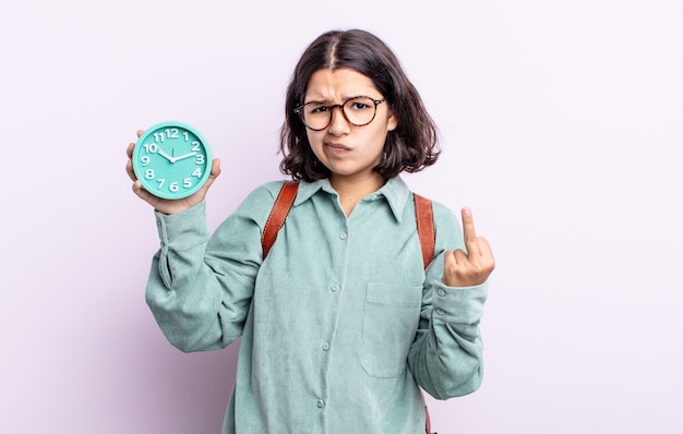 Photo pretty young woman feeling angry, annoyed, rebellious and aggressive. alarm clock concept