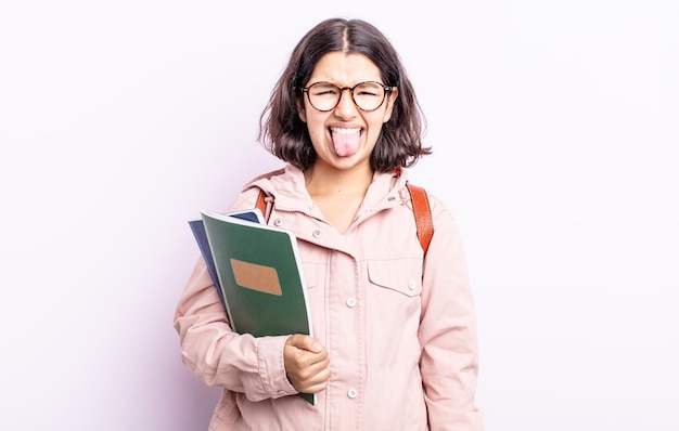Pretty young woman feeling disgusted and irritated and tongue out. student with books concept
