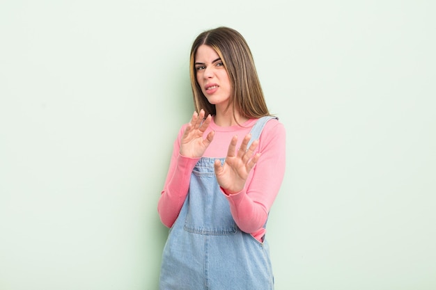 Pretty young woman feeling disgusted and nauseous, backing away from something nasty, smelly or stinky, saying yuck