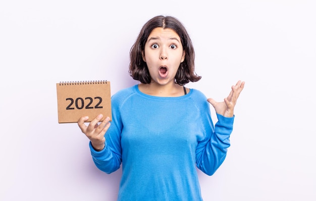 Pretty young woman feeling extremely shocked and surprised 2022 calendar concept