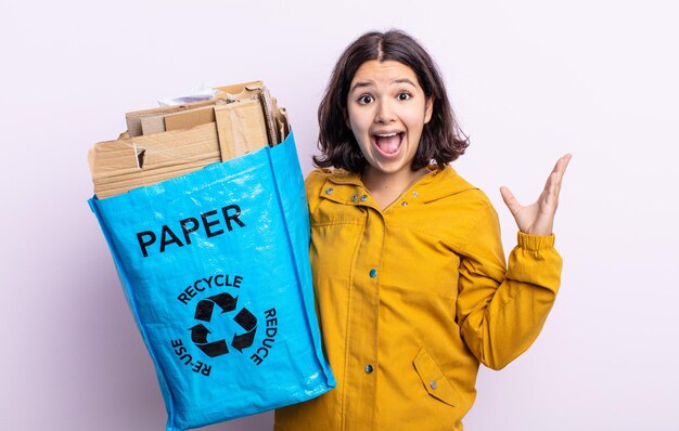 Pretty young woman feeling happy and astonished at something unbelievable paper recycle concept