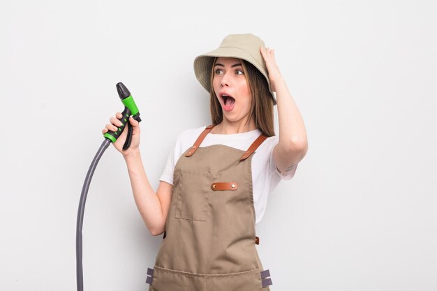 Pretty young woman feeling happy excited and surprised gardener watering concept