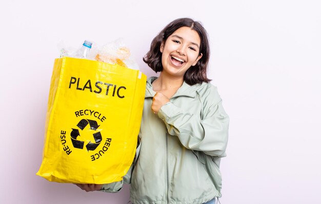 幸せを感じ、挑戦や祝いに直面しているかなり若い女性。プラスチックリサイクルの概念