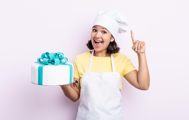 Pretty young woman feeling like a happy and excited genius after realizing an idea. chef cooking a cake