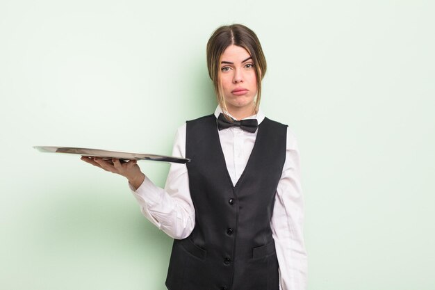 pretty young woman feeling sad and whiney with an unhappy look and crying. waiter with a tray concept