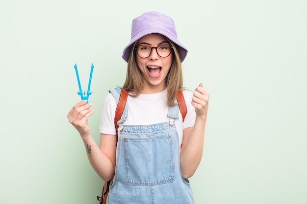 ショックを受けて笑って成功を祝う学生の概念を感じているかなり若い女性