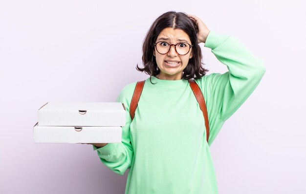 Pretty young woman feeling stressed anxious or scared with hands on head take away concept