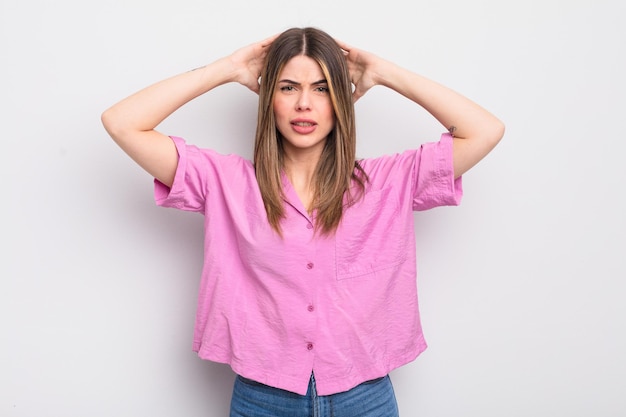 Pretty young woman feeling stressed, worried, anxious or scared, with hands on head, panicking at mistake