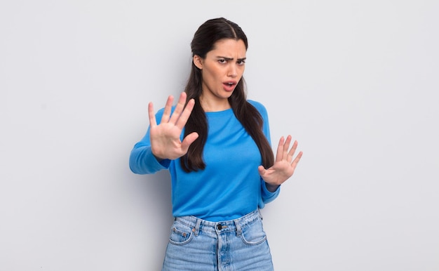 Pretty young woman feeling terrified backing off and screaming in horror and panic reacting to a nightmare