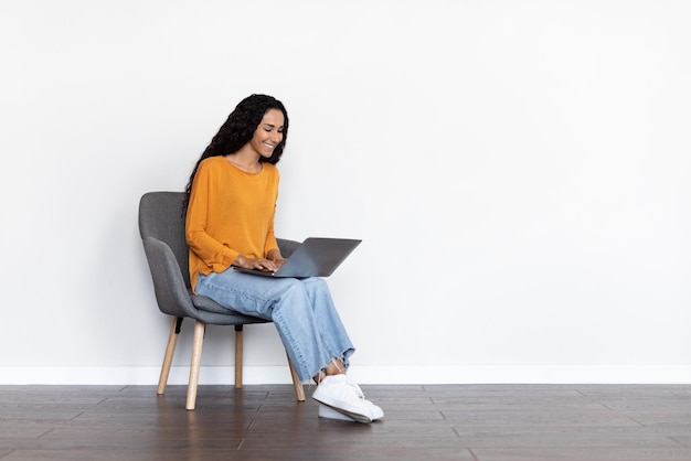 Pretty young woman freelancer using computer at home copy space