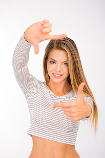 Foto piuttosto giovane donna gesticolando cornice dito