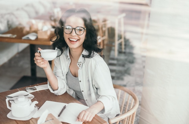 カフェでリラックスしたメガネのかなり若い女性