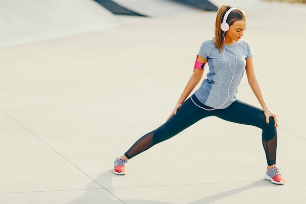 Pretty young woman having exercise outdoors