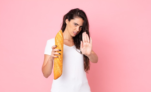 Pretty young woman holding a bread baguette