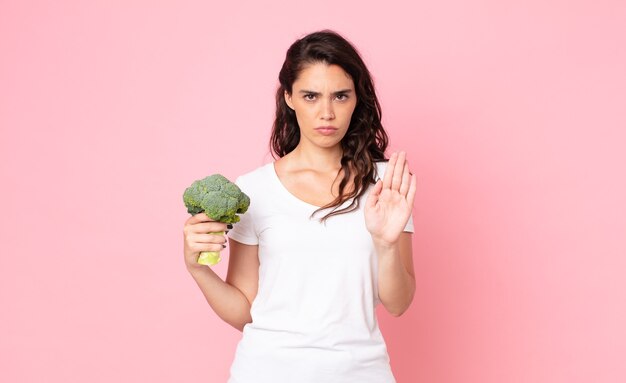 Donna abbastanza giovane che tiene un broccolo