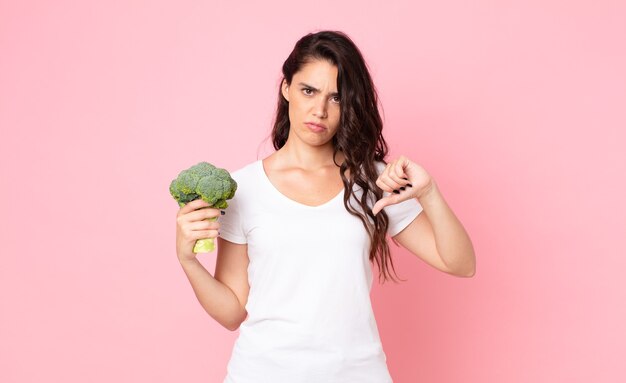 Pretty young woman holding a broccoli