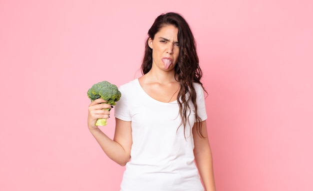 Pretty young woman holding a broccoli