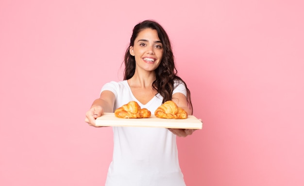 Pretty young woman holding a croissant tray