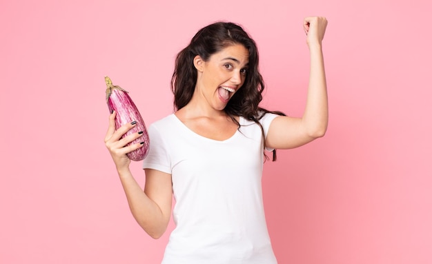 Pretty young woman holding an eggplant