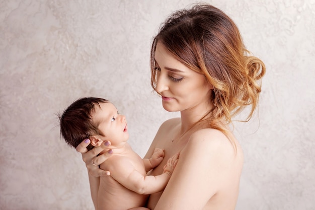 Pretty young woman holding a newborn baby in her arms