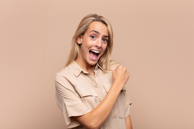 pretty young woman isolated against flat color wall